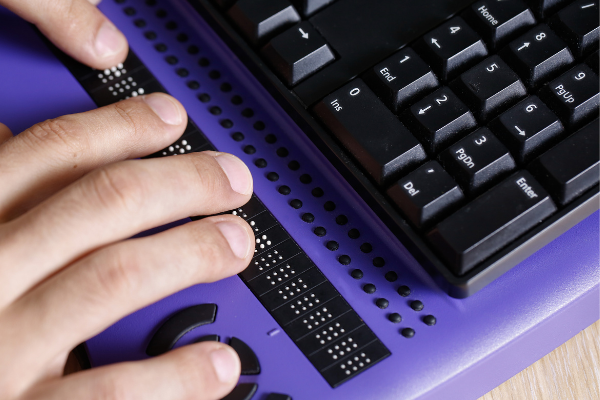 Hands typing on a braille note taker